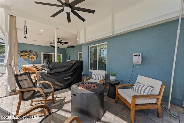 view of patio / terrace featuring ceiling fan and a fire pit