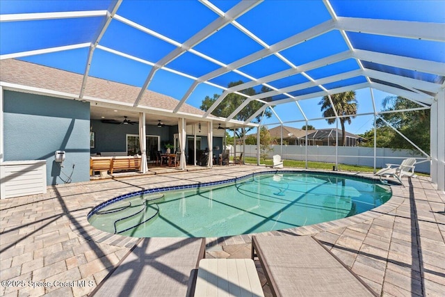 view of pool with fence, a lanai, a patio, a fenced in pool, and a ceiling fan
