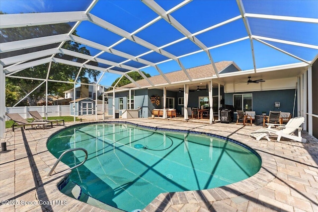 view of swimming pool with an outdoor structure, a storage shed, a ceiling fan, and a patio area