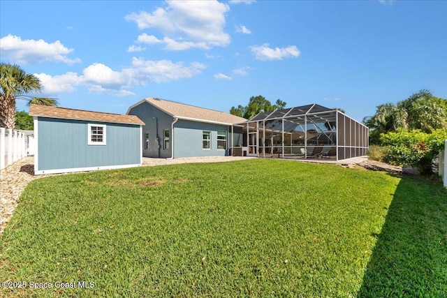 back of house featuring fence, a lanai, an outbuilding, a yard, and a shed