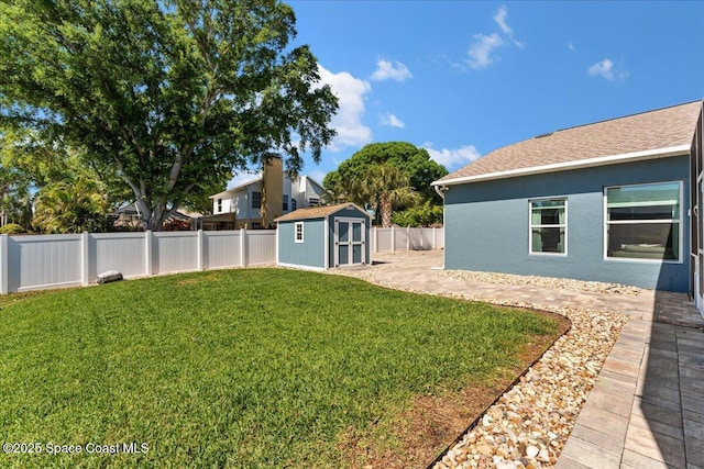 view of yard featuring an outbuilding, a fenced backyard, and a storage shed