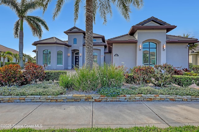 mediterranean / spanish-style house with stucco siding and a tiled roof