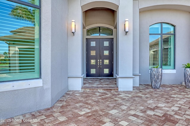 doorway to property featuring stucco siding