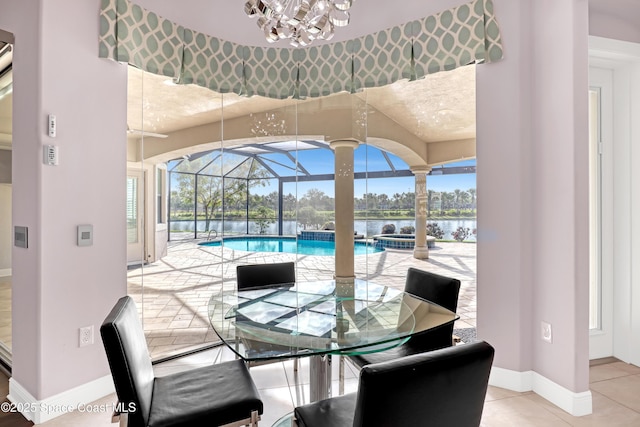 dining room with a notable chandelier, baseboards, a sunroom, and a healthy amount of sunlight