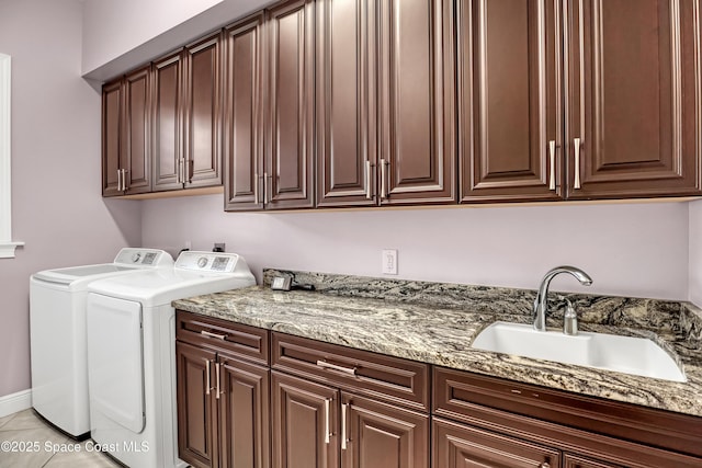 clothes washing area featuring independent washer and dryer, a sink, and cabinet space