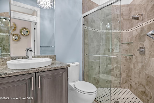 bathroom with toilet, a stall shower, and vanity