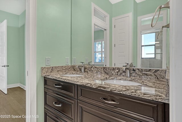 full bath with plenty of natural light, double vanity, and a sink