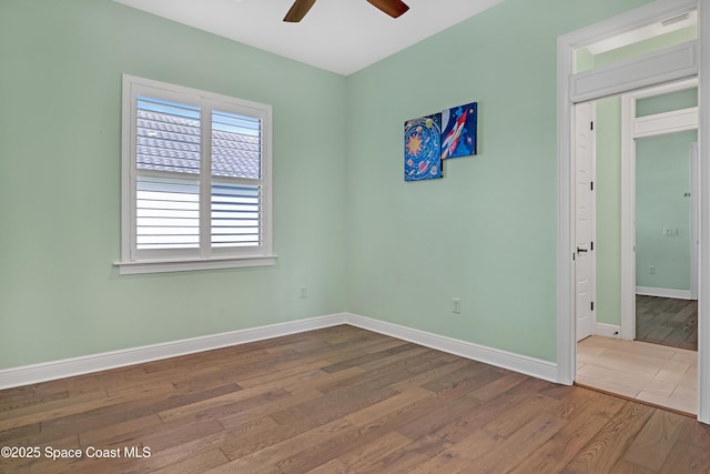 unfurnished room with wood finished floors, ceiling fan, and baseboards