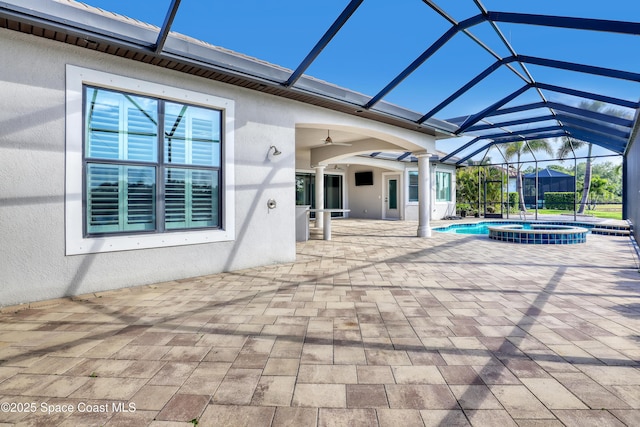 view of patio with a pool with connected hot tub, a ceiling fan, and glass enclosure