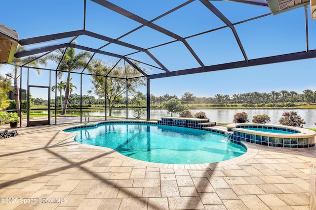 view of pool featuring a patio, a pool with connected hot tub, glass enclosure, and a water view