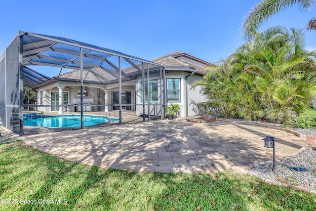 back of house featuring an outdoor pool, a patio, stucco siding, and a lanai