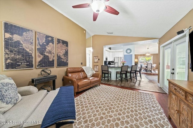living room featuring visible vents, lofted ceiling, ceiling fan, and wood finished floors