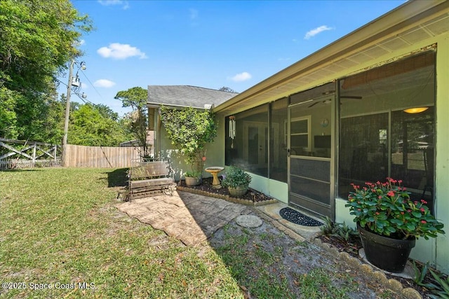 view of yard featuring a sunroom and fence