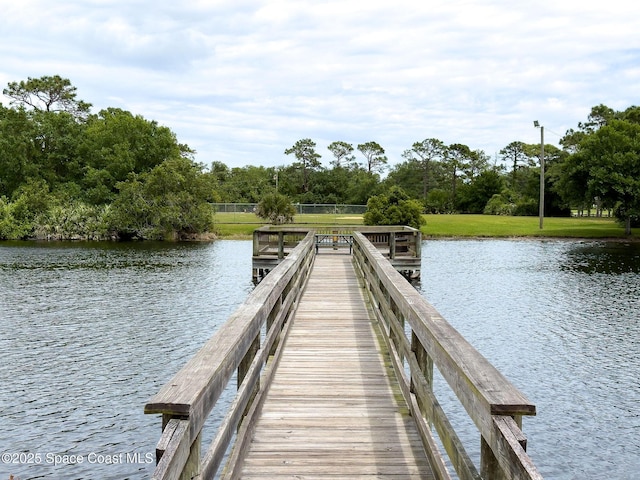 view of dock featuring a water view and a lawn