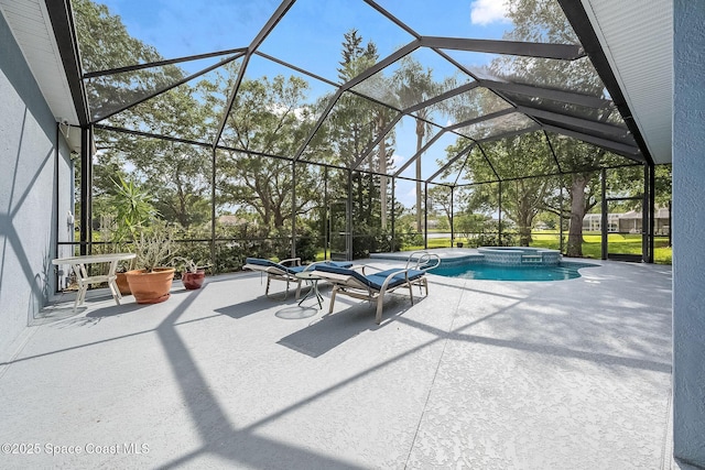view of swimming pool featuring a patio, a pool with connected hot tub, and a lanai