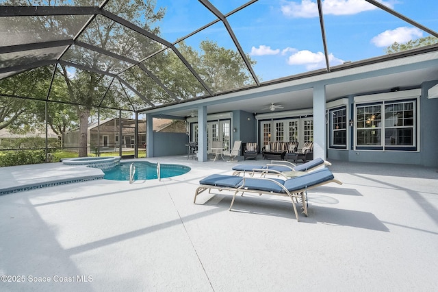 view of pool with a pool with connected hot tub, outdoor lounge area, a ceiling fan, glass enclosure, and a patio