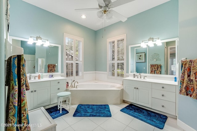 full bath featuring a sink, tile patterned floors, a bath, and two vanities