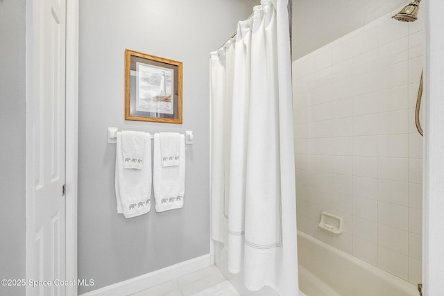 bathroom with tile patterned flooring, shower / bathtub combination with curtain, and baseboards