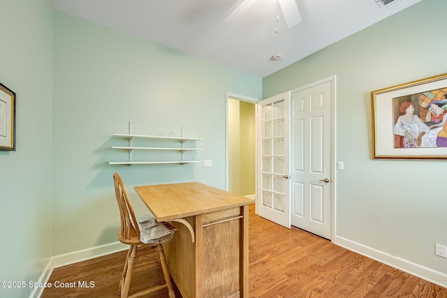 office area featuring baseboards, a ceiling fan, and light wood-style floors