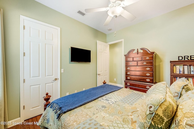 bedroom with visible vents, baseboards, a ceiling fan, and wood finished floors