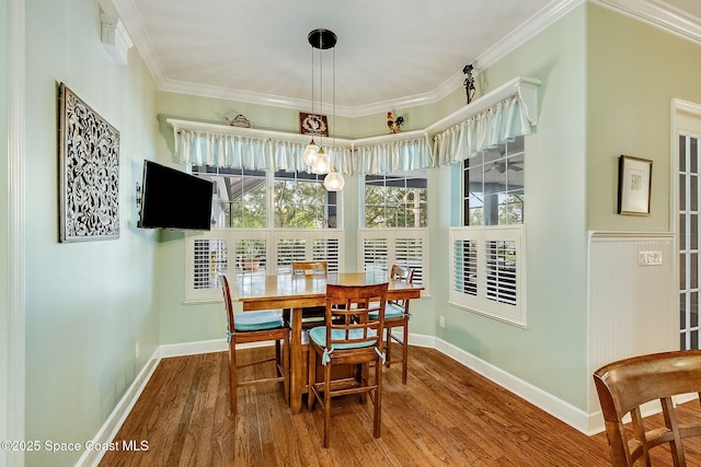 dining space with ornamental molding, baseboards, and wood finished floors