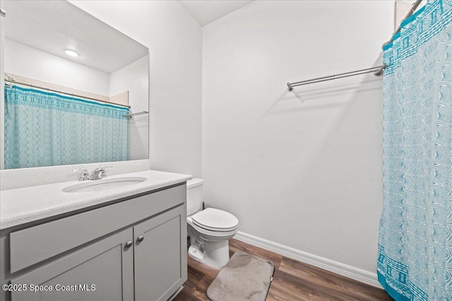 710 Mulberry St, Sebastian, FL 32958 - full bath with wood finished floors, a shower with curtain, toilet, vanity, and baseboards