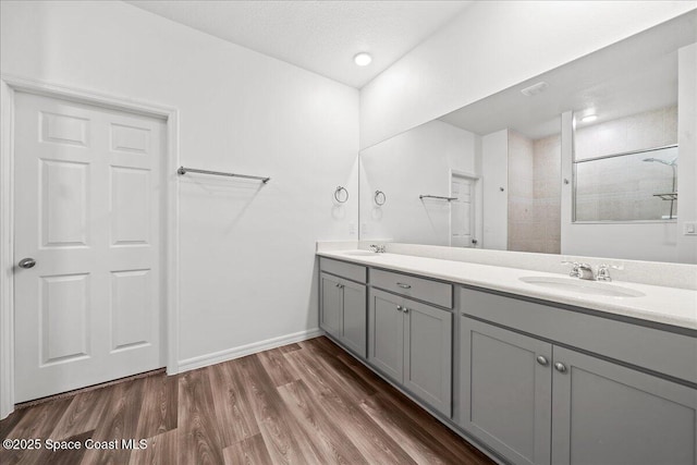 710 Mulberry St, Sebastian, FL 32958 - bathroom featuring wood finished floors, a tile shower, double vanity, and a sink