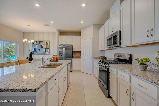 3150 Viridian Cir, Melbourne, FL 32904 - kitchen with white cabinetry, an inviting chandelier, light tile patterned floors, stainless steel appliances, and a sink