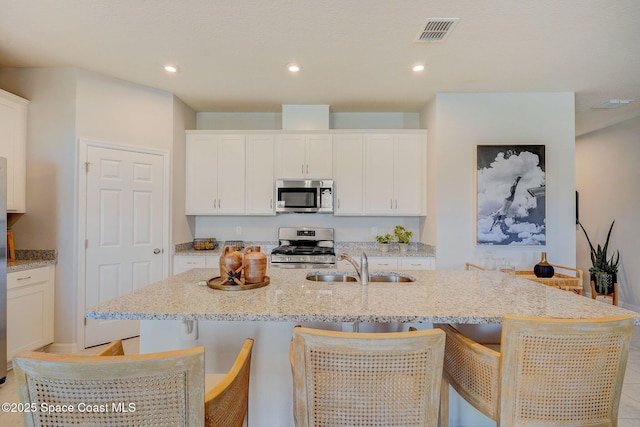 3150 Viridian Cir, Melbourne, FL 32904 - kitchen featuring white cabinets, a sink, stainless steel appliances, and an island with sink