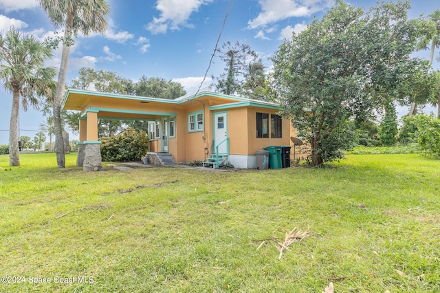 1632 Water Dr NE, Palm Bay, FL 32905 - rear view of property with a lawn, stucco siding, and entry steps