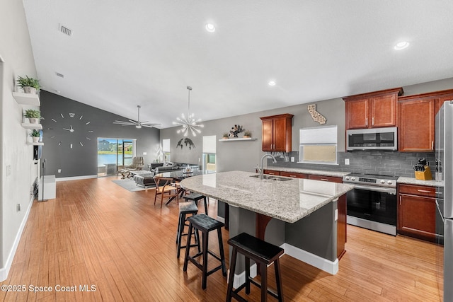 759 Fiddleleaf Cir, Melbourne, FL 32904 - kitchen featuring appliances with stainless steel finishes, a sink, open floor plan, tasteful backsplash, and an island with sink