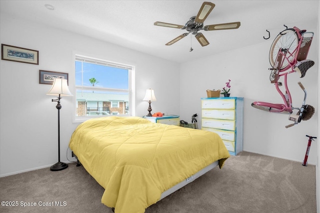 carpeted bedroom featuring baseboards and a ceiling fan