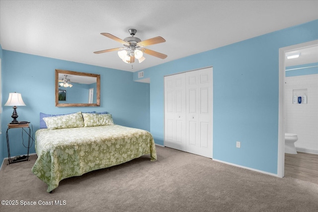 carpeted bedroom featuring a closet, visible vents, baseboards, ceiling fan, and connected bathroom