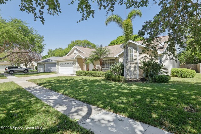 view of front of property featuring fence, driveway, a front yard, and a garage