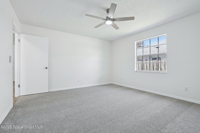 unfurnished room featuring a textured ceiling, carpet floors, ceiling fan, and baseboards