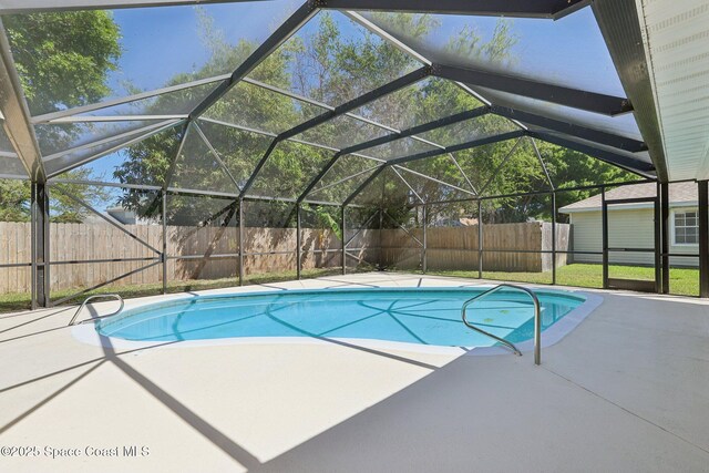 view of swimming pool with a patio, a fenced in pool, a fenced backyard, and a lanai