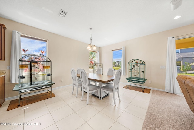 dining space featuring baseboards, visible vents, an inviting chandelier, and a healthy amount of sunlight