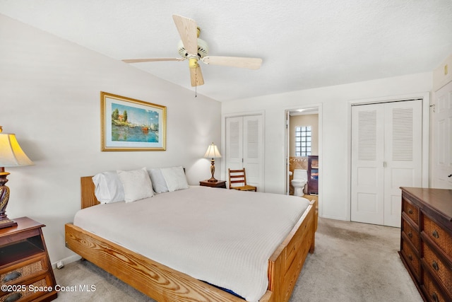 1445 Centaurus Ct, Merritt Island, FL 32953 - bedroom featuring light colored carpet, two closets, ensuite bath, and a ceiling fan