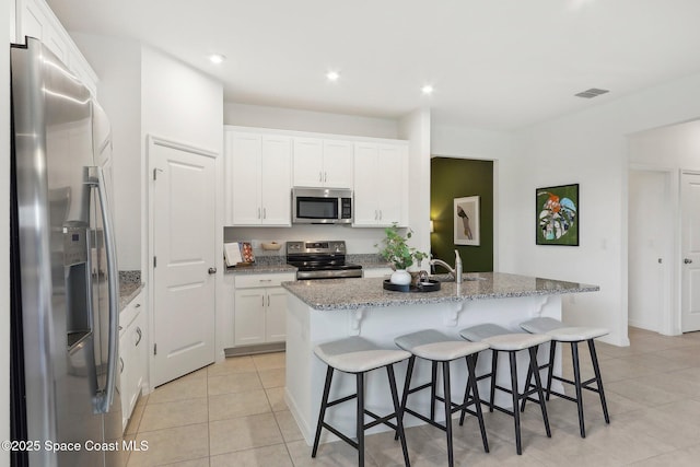 3175 Viridian Cir, Melbourne, FL 32904 - kitchen with white cabinetry, stainless steel appliances, an island with sink, and visible vents