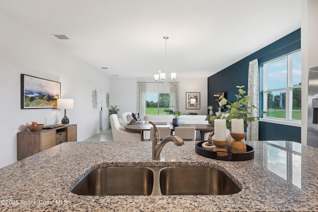 3175 Viridian Cir, Melbourne, FL 32904 - kitchen with light stone countertops, a sink, a healthy amount of sunlight, and visible vents
