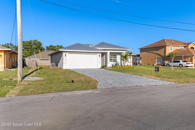 5271 NW Mayfield Ln, Port St Lucie, FL 34983 - view of front of house with a front yard, stucco siding, fence, an attached garage, and decorative driveway