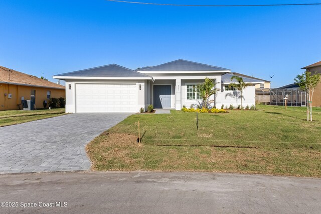 5271 NW Mayfield Ln, Port St Lucie, FL 34983 - view of front of property with central AC unit, decorative driveway, a garage, a front lawn, and stucco siding