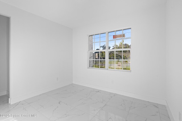 5271 NW Mayfield Ln, Port St Lucie, FL 34983 - spare room featuring marble finish floor and baseboards