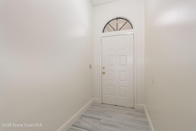 doorway featuring baseboards and light wood-style floors