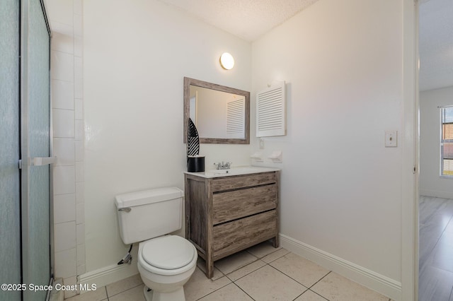 full bath with tile patterned floors, toilet, baseboards, and a textured ceiling