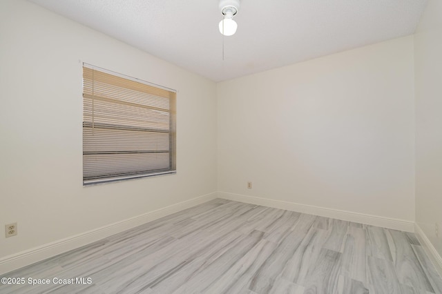 empty room featuring baseboards and light wood-style flooring