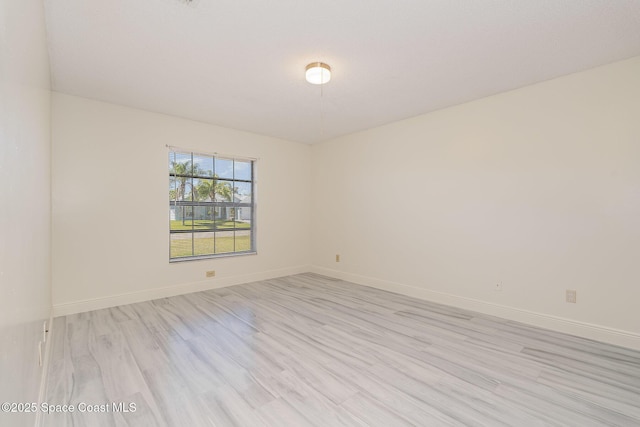 unfurnished room with baseboards and light wood-style floors
