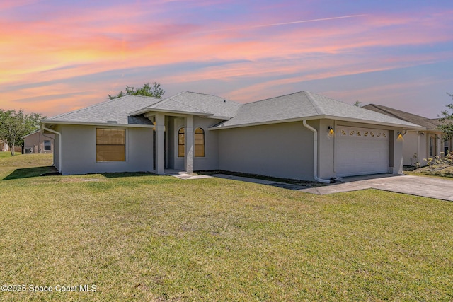 view of front of home featuring concrete driveway, stucco siding, roof with shingles, an attached garage, and a front yard