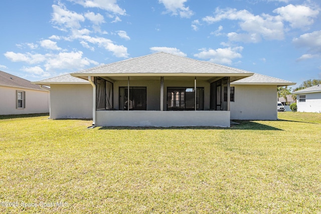 back of property featuring stucco siding, a sunroom, roof with shingles, and a yard