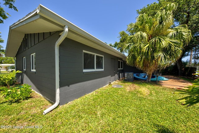 view of side of property featuring a yard and central AC unit